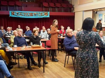 Bosnische Marija en Dayana presenteren hun Caritasverhaal voor een goed gevulde zaal.